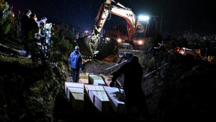 Des personnes déposent dans une fosse commune les cercueils de victimes tuées lors d'une frappe aérienne pakistanaise contre un hôpital pour toxicomanes, le 18  mars 2018 à Kaboul