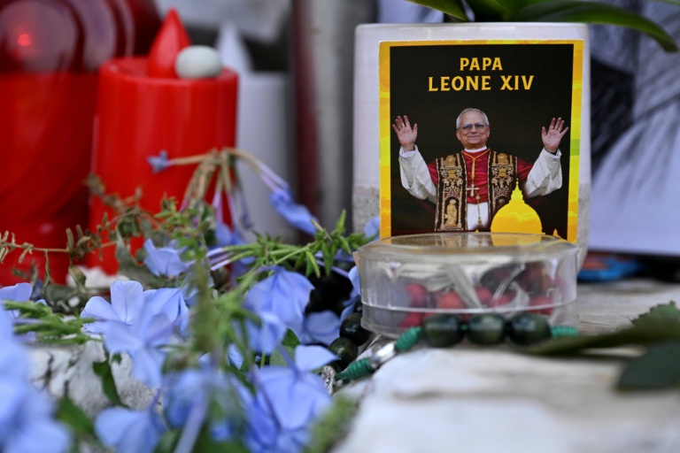 Des fleurs, des bougies et une photo du pape Léon XIV déposées au pied de la statue de Jean-Paul II, devant l’hôpital Gemelli à Rome où le pape Léon XIV est en convalescence, le 17 octobre 2026