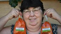La cultivatrice Rozsa Benyi pose avec deux sachets de paprika devant son domicile à Homokmegy, dans le sud de la Hongrie, le 19 septembre 2026 