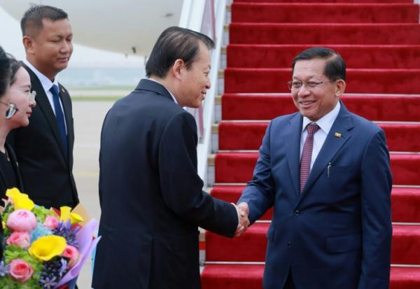 Photo diffusée le 15 juin 2026 par le Bureau de presse et d'information de la présidence birmane, montrant le président birman Min Aung Hlaing (d) accueilli par un responsable chinois à son arrivée à Pékin