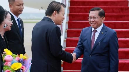 Photo diffusée le 15 juin 2026 par le Bureau de presse et d'information de la présidence birmane, montrant le président birman Min Aung Hlaing (d) accueilli par un responsable chinois à son arrivée à Pékin