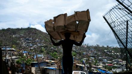 Un homme transporte des matériaux pour reconstruire sa maison à Mamoudzou, à Mayotte, le 2 janvier 2025