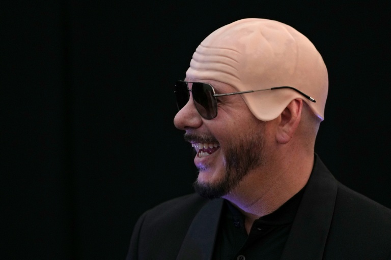 Le rappeur américain Pitbull porte un faux crâne chauve en latex après avoir établi un record Guinness du plus grand rassemblement de personnes portant de faux crânes chauves, le 10 juillet 2026 à Londres