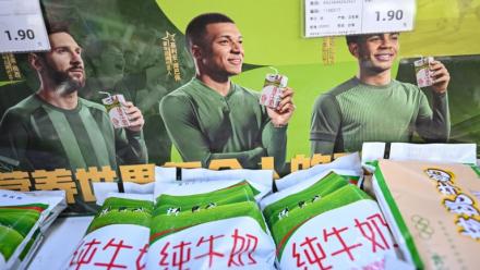 Les portraits des footballeurs Lionel Messi (g), Kylian Mbappé (c) et Lamine Yamal sur une affiche publicitaire de la marque de produits laitiers Mengniu, le 28 octobre 2026 dans un supermarché à Pékin