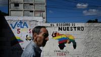 Un homme passe devant une fresque murale faisant campagne pour un référendum demandant aux Vénézuéliens d'envisager l'annexion de la région de l'Essequibo administrée par le Guyana, à Caracas, le 28 novembre 2023