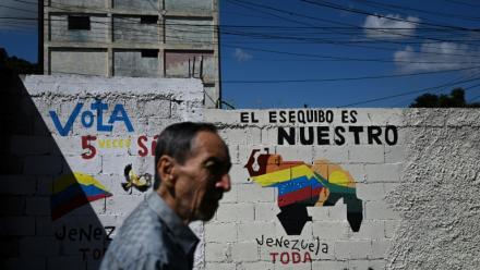 Un homme passe devant une fresque murale faisant campagne pour un référendum demandant aux Vénézuéliens d'envisager l'annexion de la région de l'Essequibo administrée par le Guyana, à Caracas, le 28 novembre 2023