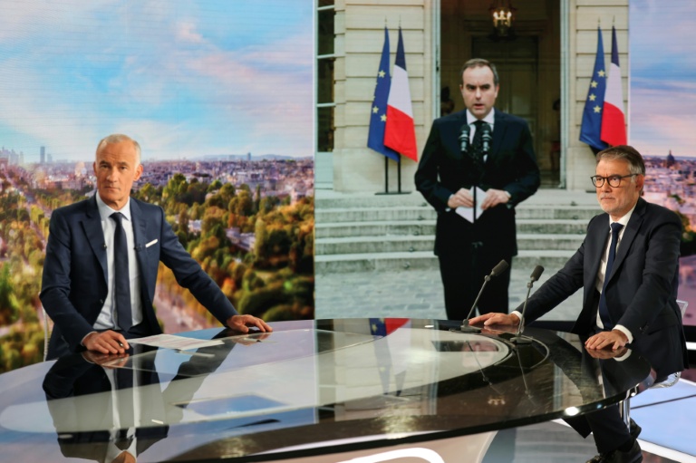 Olivier Faure (d), premier secrétaire du Parti socialiste et le journaliste Gilles Bouleau, devant une photo du Premier ministre démissionnaire Sébastien Lecornu, sur le plateau du 20h de TF1, à Boulogne-Billancourt, le 6 octobre 2025
