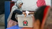 Une électrice (g) vote  à Dacca, lors des élections législatives au Bangladesh, le 12 février 2026