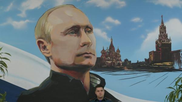 Un panneau mural représentant Vladimir Poutine et la Place rouge, le 20 septembre 2026 dans un bureau de vote de Donetsk, dans les territoires ukrainiens occupés par la Russie

