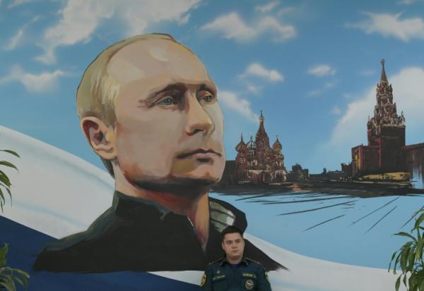 Un panneau mural représentant Vladimir Poutine et la Place rouge, le 20 septembre 2026 dans un bureau de vote de Donetsk, dans les territoires ukrainiens occupés par la Russie

