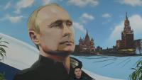 Un panneau mural représentant Vladimir Poutine et la Place rouge, le 20 septembre 2026 dans un bureau de vote de Donetsk, dans les territoires ukrainiens occupés par la Russie

