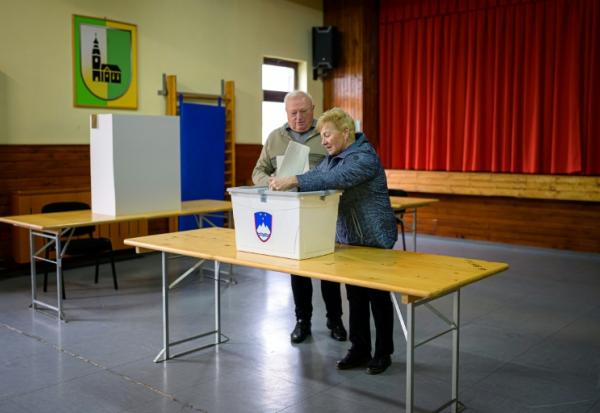 Un couple de personnes âgées vote aux élections législatives, le 22 mars 2026 à Arnace en Slovénie 