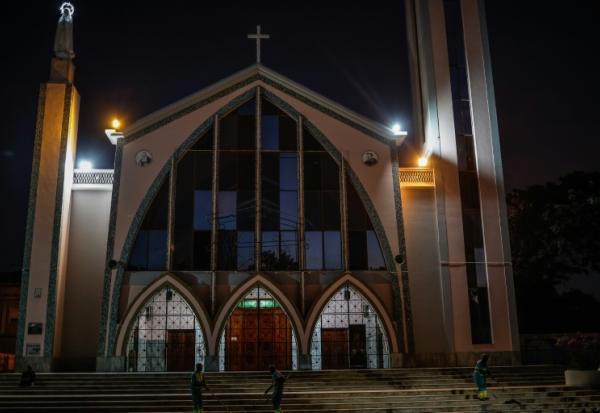 Des ouvriers nettoient les abords de la paroisse Notre-Dame de Fatima à Luanda, en Angola, le 17 avril 2026, en prévision de la visite du pape Léon XIV