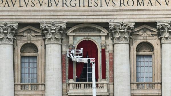 Un ouvrier sur une nacelle prépare le balcon de la loggia centrale de la basilique Saint-Pierre au Vatican où le nom du nouveau pape sera annoncé, le 5 mai 2025