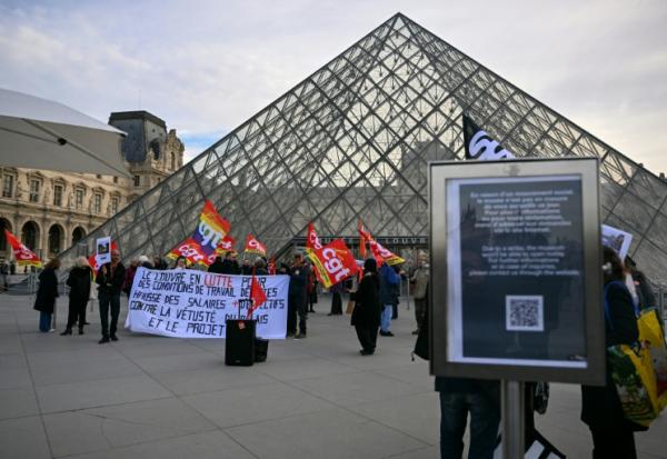 Des membres du syndicat CGT manifestent devant l'entrée du Louvre, à Paris, le 15 décembre 2025