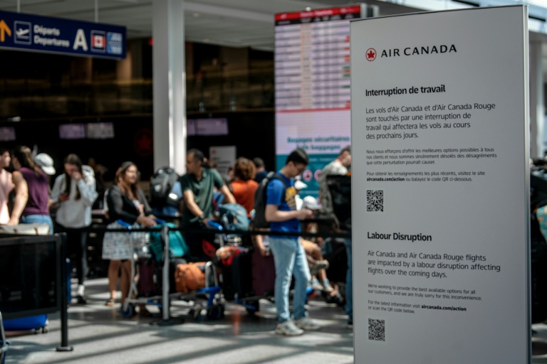 Des passagers en attente à l'aéroport de Montréal (Canada) le 16 août 2025 à la suite d'un mouvement de grève des hôtesses et stewards d'Air Canada