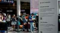 Des passagers en attente à l'aéroport de Montréal (Canada) le 16 août 2025 à la suite d'un mouvement de grève des hôtesses et stewards d'Air Canada