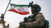 Cette photographie fournie par le Corps des Marines des États-Unis, prise le 16 juillet 2026 par le service des relations publiques du Commandement central américain, montrerait un drapeau iranien flottant derrière un marine américain de la 11e Unité expéditionnaire des Marines, dans le Golfe.