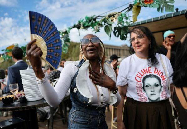 Des fans de la chanteuse canadienne Céline Dion portant des accessoires -éventail, T-shirt, etc. à son effigie- participent à une croisière hommage à leur idole sur la Seine à Paris, le 13 septembre 2026