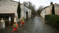 Des sauveteurs en mer dans une rue inondée lors d'une opération visant à évacuer des habitants isolés à Courcoury, en Charente-Maritime, le 21 février 2026