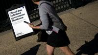 Une femme passe devant une pancarte de la National Gallery of Art à Washington, annonçant que le musée est fermé en raison du blocage budgétaire en cours au Congrès, le 6 octobre 2025