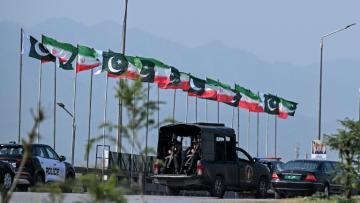 Des drapeaux iraniens et pakistanais le long de la route empruntée par le cortège du président iranien Massoud à son arrivée à Islamabad, le 23 juin 2026 au Pakistan
