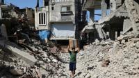 Un garçon palestinien déplacé porte une boîte de fournitures d'urgence fournies par le Programme alimentaire mondial (PAM) après l'avoir reçue d'un point de distribution d'aide au camp de réfugiés de Nuseirat dans le centre de la bande de Gaza, le 19 octobre 2025