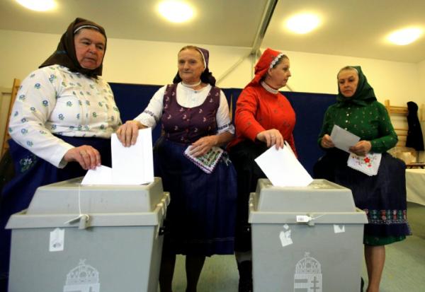 Des femmes en tenue traditionnelle votent dans une école maternelle à Veresegyhaz, près de Budapest, le 12 avril 2026