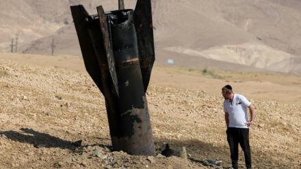 Un Israélien inspecte un missile tombé, à moitié enfoui dans le sol, en périphérie de Jéricho en Cisjordanie, le 8 juin 2026