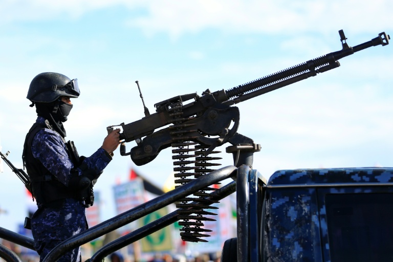 Un agent de sécurité monte la garde lors d'un rassemblement de partisans houthis en solidarité avec l'Iran et le Liban à Sanaa, le 27 mars 2026 au Yémen