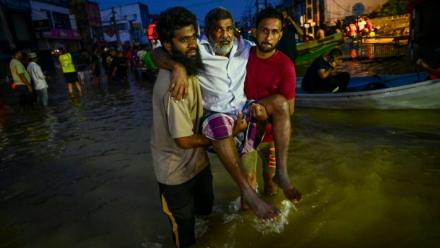 De jeunes hommes portent une personne âgée dans une rue inondée de Wellampitiya, dans les faubourgs de Colombo, la capitale du Sri Lanka, le 30 novembre 2025