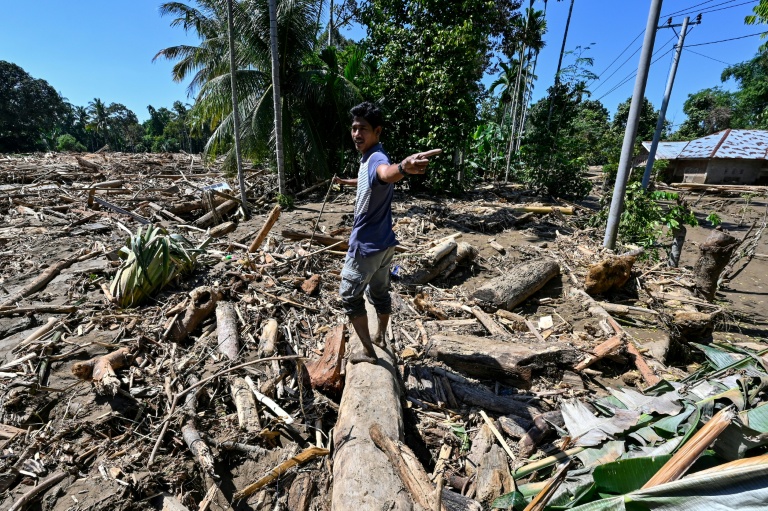 Un homme contemple les dégâts dans une zone dévastée par les inondations à Meureudu, dans la province indonésienne d'Aceh, le 30 novembre 2025
