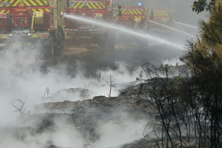 Des pompiers effectuent des opérations de noyage — éteignant les derniers points chauds et foyers encore fumants — dans une forêt près de Marcheprime, à une trentaine de kilomètres de Bordeaux, le 27 juillet 2026