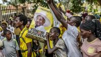De jeunes partisans du président ougandais sortant Yoweri Museveni brandissent des affiches électorales et chantent des slogans à son dernier meeting de campagne, le 13 janvier 2026 à Kampala