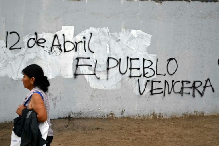 Une femme passe devant une affiche faisant référence à la date de l’élection présidentielle et des législatives au Pérou, un pays où le vote est obligatoire et qui a connu huit présidents depuis 2016