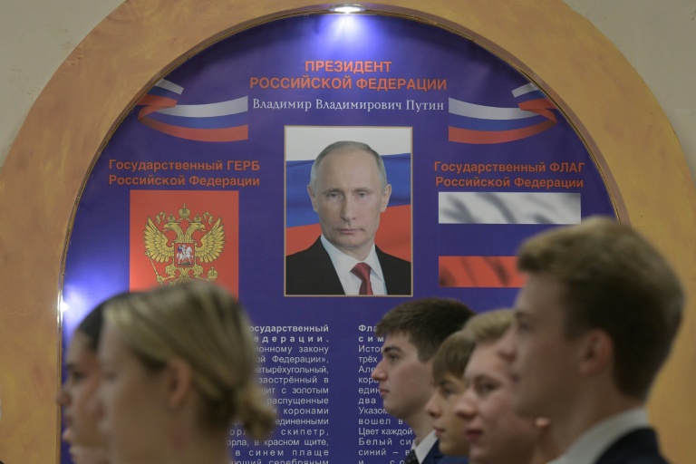 Des élèves d'un lycée font la file pour chanter l'hymne national russe lors de l'ouverture du scrutin dans un bureau de vote installé dans l'enceinte du lycée, à l'occasion des élections législatives russes à Donetsk, dans l'est de l'Ukraine sous contrôle russe, le 18 septembre 2026
