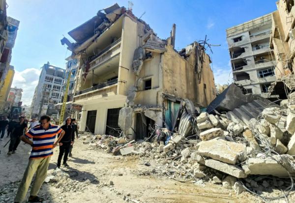 Des habitants devant les décombres de bâtiments endommagés et effondrés après des frappes israéliennes nocturnes sur la ville de Tyr, dans le sud du Liban, le 16 mai 2026