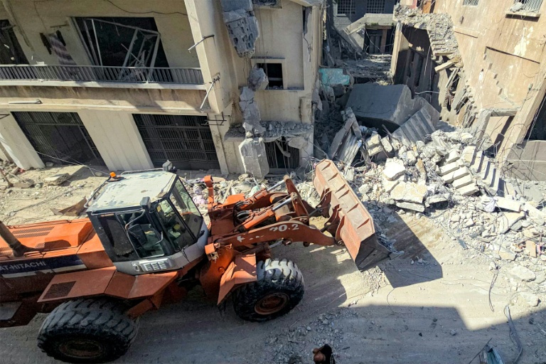 Un engin de chantier dégage les décombres de bâtiment détruits par des frappes israéliennes nocturnes sur la ville de Tyr, dans le sud du Liban, le 16 mai 2026 