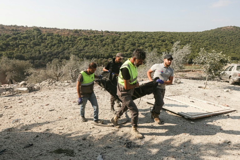 Les premiers secours évacuent un corps des décombres à la suite d'une frappe aérienne israélienne qui a visé une maison dans le village d'Ansar, dans le sud du Liban, le 15 août 2026. 