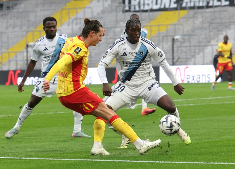 Le Lensois Florian Thauvin (g) aux prises avec le défenseur du Paris FC Nhoa Sangui lors de la victoire des Sang et Or 2-1, le 19 octobre 2025 à Lens