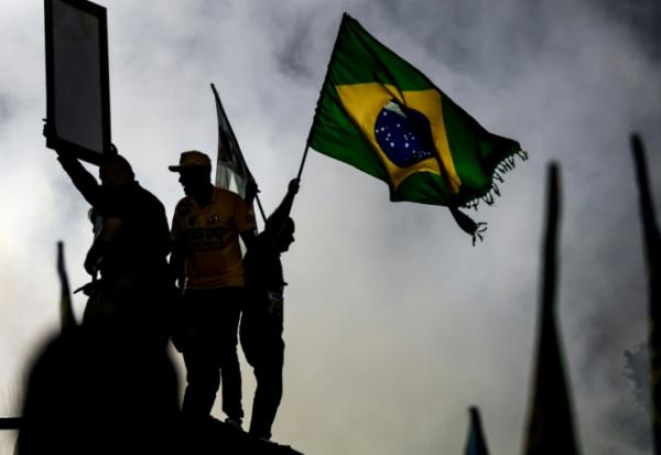 Un partisan du sénateur brésilien de droite et candidat à la présidence, Flavio Bolsonaro, agite un drapeau national lors d'un meeting de campagne à  Rio de Janeiro, le 3 octobre 2026