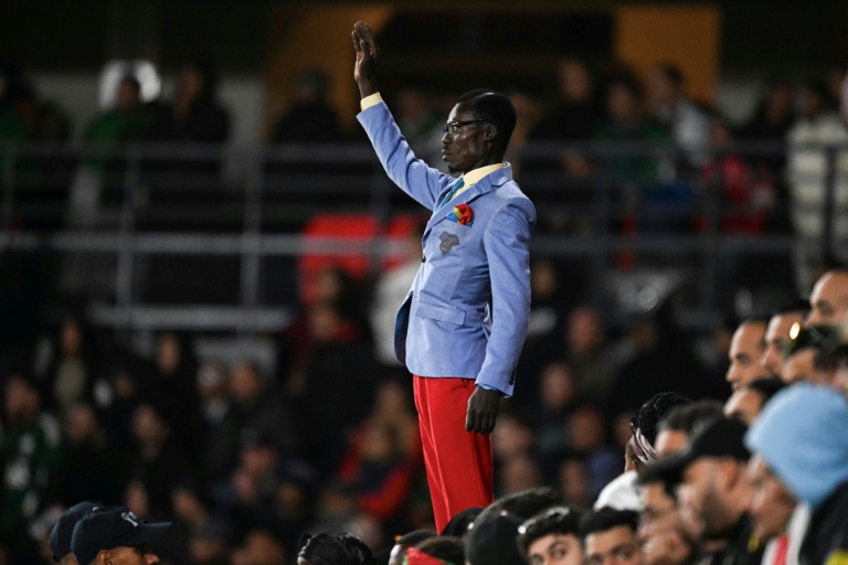 Le supporter congolais Michel Kuka Mboladinga rend hommage à l'ancien Premier ministre congolais, Patrice Lumumba, debout, le bras levé, avant le match de huitièmes de finale de la CAN entre l'Algérie et la RDC au stade Prince Moulay El Hassan de Rabat, le 6 janvier 2026 au Maroc
