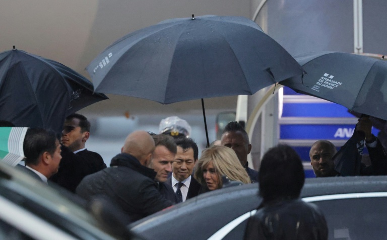 Le président français Emmanuel Macron (c,g) et son épouse Brigitte Macron à leur arrivée à l'aéroport de Tokyo, le 31 mars 2026