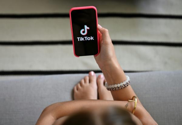 Une jeune fille tient son smartphone, sur lequel apparaît le logo du réseau social Tik Tok, le 7 juillet 2026 à Bruxelles 