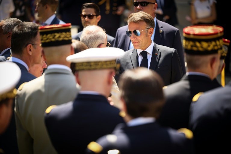 Le président Emmanuel Macron (c) salue des officiers supérieurs à l'issue du traditionnel discours aux armées à l'hôtel de Brienne, à Paris, le 13 juillet 2026, à la veille du défilé annuel du 14 Juillet