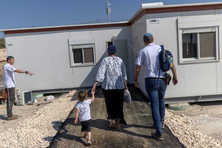 Des colons israéliens devant une maison après la réouverture d'une colonie à Ganim, en Cisjordanie occupée, le 13 août 2026