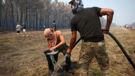Un volontaire remplit un seau d’eau pour aider à lutter contre l’incendie dans une forêt à Lanton, à l’ouest de Bordeaux, le 29 juillet 2026, lors des feux de forêt dans le département de la Gironde, dans le sud-ouest de la France