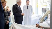 Photo publiée par les services de la présidence italienne montrant le président Sergio Mattarella (C) et la présidente du Conseil Giorgia Meloni (G) au chevet d'une des victimes renversées par un conducteur ayant des antécédents psychiatriques, le 17 mai 2026 à Modène
