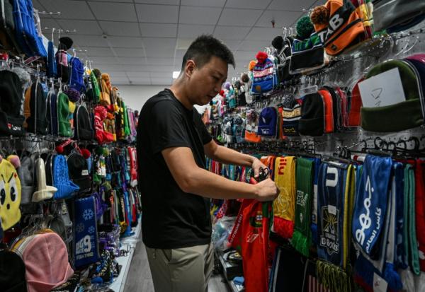 Shang Yabing, le directeur, trie des produits dans une salle d'exposition d'une usine qui produit des chapeaux et des écharpes à Yiwu, dans la province du Zhejiang, dans l'est de la Chine, le 18 septembre 2025