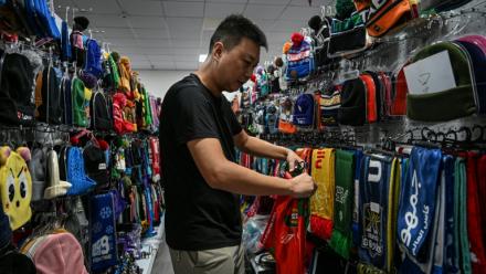 Shang Yabing, le directeur, trie des produits dans une salle d'exposition d'une usine qui produit des chapeaux et des écharpes à Yiwu, dans la province du Zhejiang, dans l'est de la Chine, le 18 septembre 2025